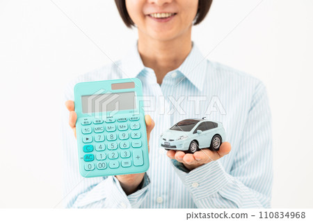 一位中年婦女拿著計算機和汽車模型微笑 110834968