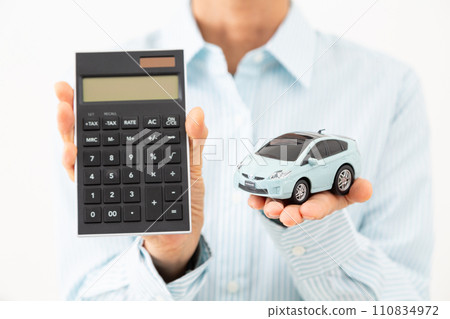 Middle-aged woman with a calculator and a car model Middle-aged woman with a calculator and a car model 110834972