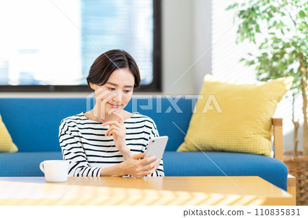 A young woman operating a smartphone. A young woman operating a smartphone. 110835831