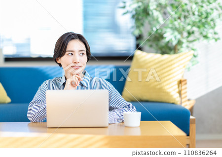 A woman operating a laptop in the living room. A woman operating a laptop in the living room. 110836264