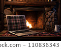 Laptop with a picture of a bonfire screen, indoor near burning fireplace in rustic style, with cozy blanket and cup of coffee. Seasonal remote work, internet, shopping. 110836343