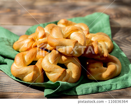 Taralli twist on wooden background. Typical italian ring-shaped or doughnut-shaped biscuit cookies or appetizers for wine Taralli or Taralle. Copy space 110836364