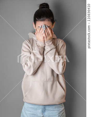 Pensive thoughtful young girl wearing sweatshirt with hood 110836410