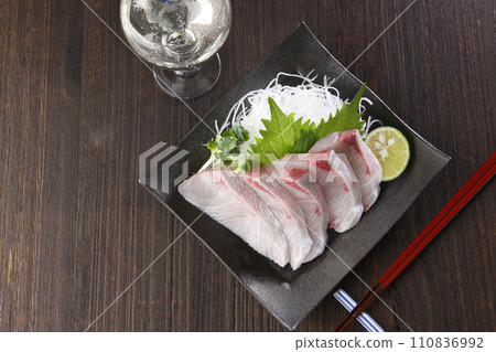 A plate of fatty amberjack sashimi and sparkling 110836992