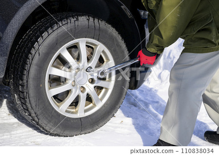 A man tightens a tire nut with a torque wrench 110838034