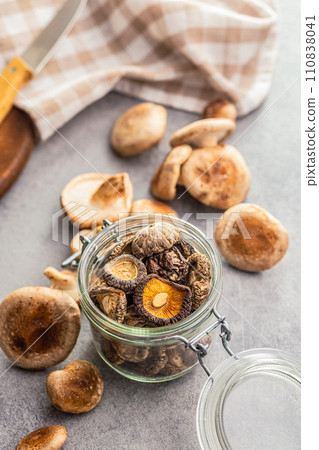 The dried shiitake mashrooms in jar on kitchen table. 110838041