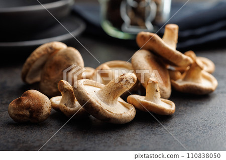 The fresh shiitake mashrooms on black table. The fresh shiitake mashrooms on black table. 110838050