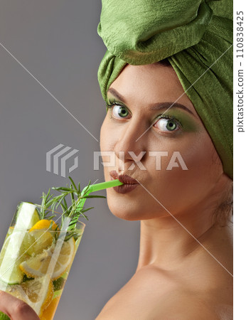 Young woman in a green turban with cocktail 110838425