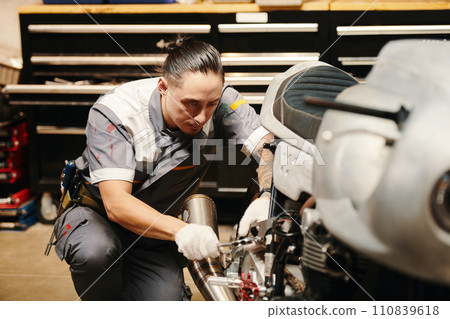Motorcycle mechanic checking wiring of motorcycle 110839618