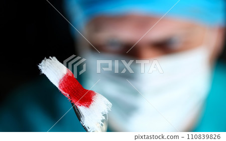 Surgeon in sterile uniform arms holding tools with bio material 110839826