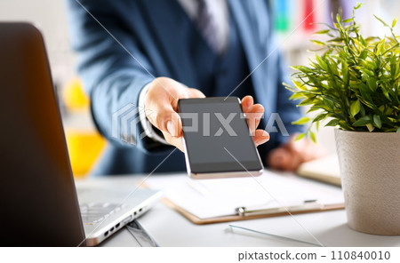 Male arm in suit show in camera phone display Male arm in suit show in camera phone display 110840010