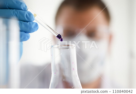 A male chemist holds test tube of glass 110840042