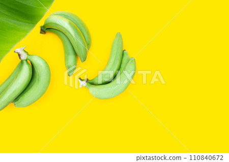 Green banana on yellow background 110840672