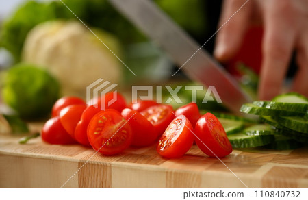 Cook holds knife in hand and cuts on Cook holds knife in hand and cuts on 110840732
