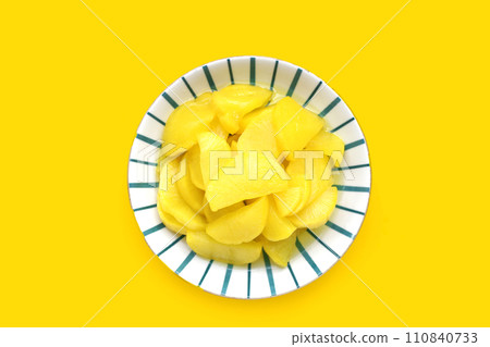 Sweet and tart slices of yellow pickled daikon, known as takuan in Japan and danmuji in Korea. Sweet and tart slices of yellow pickled daikon, known as takuan in Japan and danmuji in Korea. 110840733