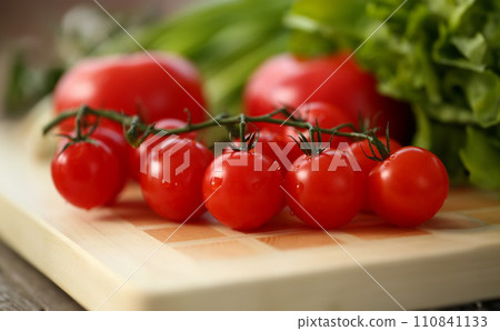 Cherry tomatoes lie on a cutting board Cherry tomatoes lie on a cutting board 110841133