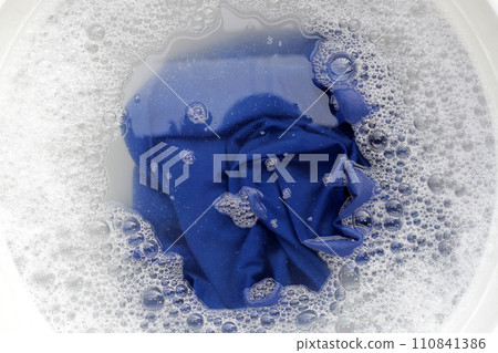 T-shirt soak in powder detergent water dissolution, washing cloth. Laundry concept T-shirt soak in powder detergent water dissolution, washing cloth. Laundry concept 110841386