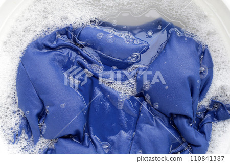 T-shirt soak in powder detergent water dissolution, washing cloth. Laundry concept T-shirt soak in powder detergent water dissolution, washing cloth. Laundry concept 110841387