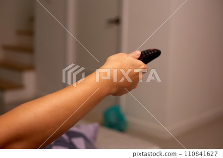 Hand holding TV remote control Hand holding TV remote control 110841627