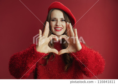 smiling trendy woman in sweater and beret showing heart hands smiling trendy woman in sweater and beret showing heart hands 110841811