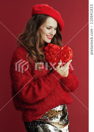 smiling trendy 40 years old woman in red sweater and beret 110841833