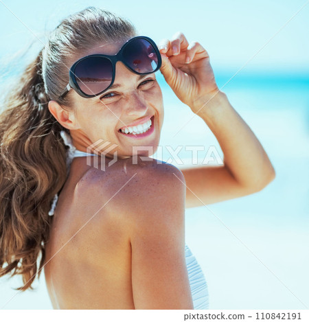 smiling woman in swimsuit with sunglasses on beach smiling woman in swimsuit with sunglasses on beach 110842191