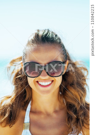 young woman in sunglasses on beach young woman in sunglasses on beach 110842215