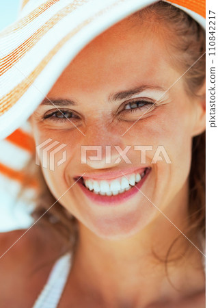 smiling young woman in hat on beach 110842217