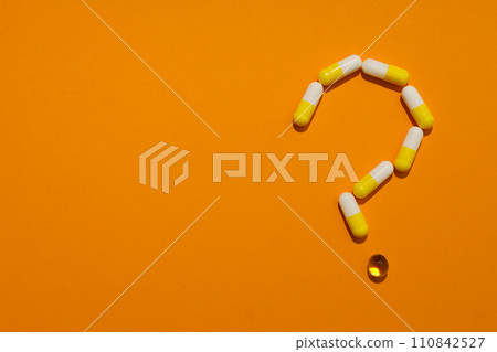 Question mark made of pills on a yellow background Question mark made of pills on a yellow background 110842527