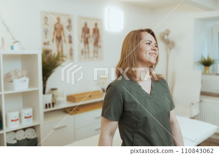 smiling female medical massage therapist in massage cabinet 110843062
