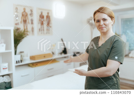 female medical massage therapist in massage cabinet welcoming female medical massage therapist in massage cabinet welcoming 110843070
