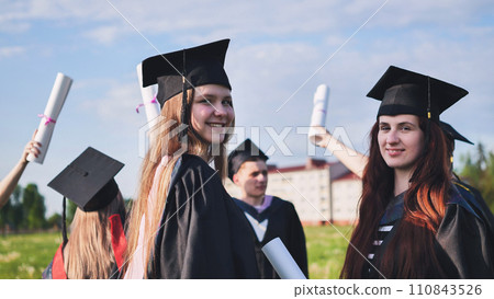 Portraits of graduating girls in black robes on the street. Portraits of graduating girls in black robes on the street. 110843526