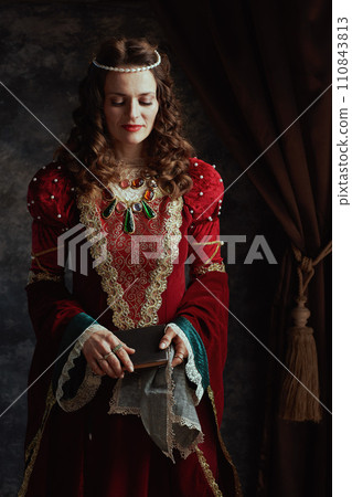 medieval queen in red dress with book and handkerchief 110843813