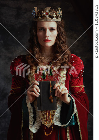 medieval queen in red dress with book, rosary and crown medieval queen in red dress with book, rosary and crown 110843815
