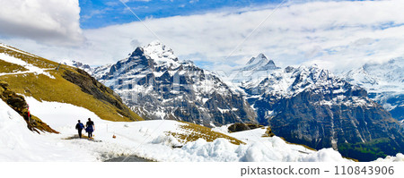 Scene with hikers walking along the alpine paths of the Bachalpsee Lake Trail in Swiss Alps Grindelwald ,Switzerland Scene with hikers walking along the alpine paths of the Bachalpsee Lake Trail in Swiss Alps Grindelwald ,Switzerland 110843906