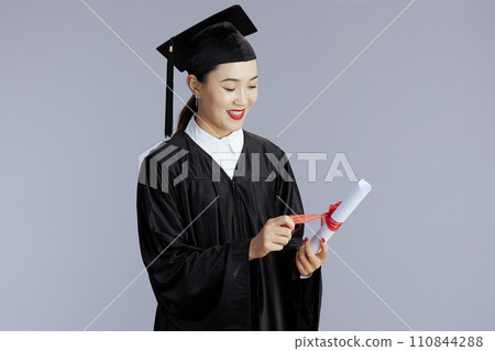 happy female asian graduate student isolated on gray happy female asian graduate student isolated on gray 110844288