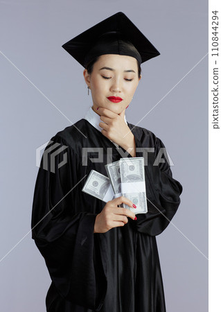 smiling female asian graduate student isolated on gray 110844294
