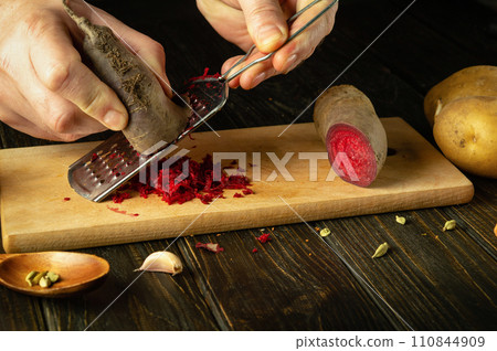 Preparing beet salad with the hands of a chef on the kitchen table. The process of preparing a healthy vegetable dish in a restaurant 110844909