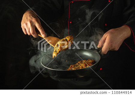 Cooking fried crucian fish in the hotel kitchen. Cook the fish in a frying pan in the hands of a chef. Idea for a delicious fish dish for breakfast Cooking fried crucian fish in the hotel kitchen. Cook the fish in a frying pan in the hands of a chef. Idea for a delicious fish dish for breakfast 110844914