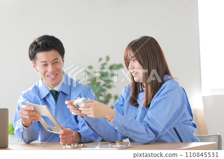 Mechanical engineers, male and female, discussing about designed aluminum products_2 110845531