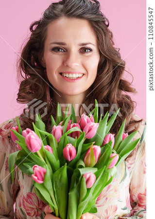 Portrait of happy stylish woman in floral dress on pink 110845547