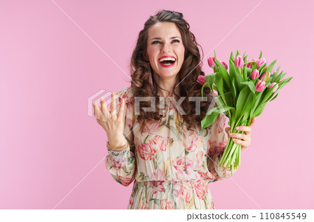 smiling young woman with long wavy brunette hair on pink 110845549