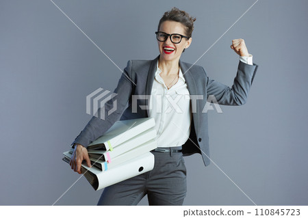 happy trendy business owner woman showing biceps against gray 110845723