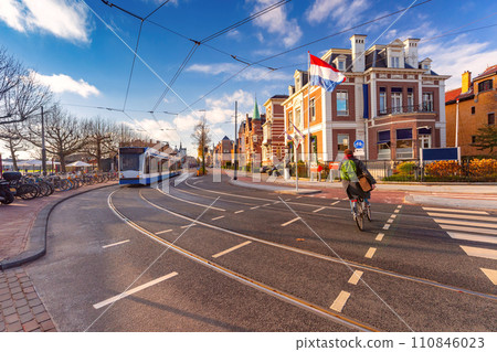 Amsterdam tram, flag and dutch houses 110846023