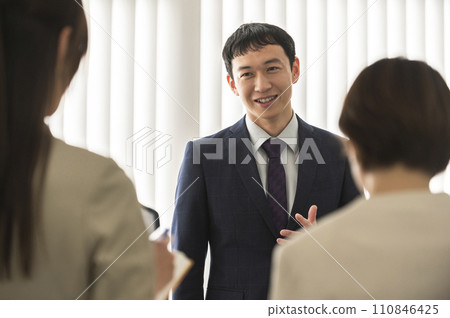 Men and women in suits having a morning assembly/meeting 110846425