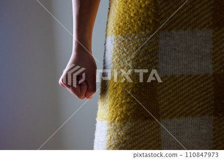 A woman's hand clenched into a fist, dark image A woman's hand clenched into a fist, dark image 110847973