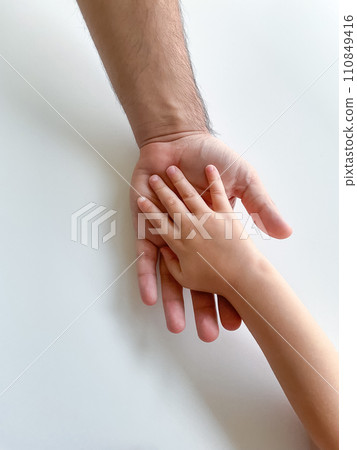 Adult and child hold their hands together. Fathers Day Child gives hand to adult Adult and child hold their hands together. Fathers Day Child gives hand to adult 110849416