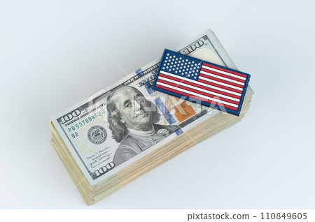 100 dollars bill pile with American flag sticker on top 110849605
