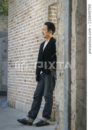 Full body portrait of a man in his mid-50s wearing a black jacket Full body portrait of a man in his mid-50s wearing a black jacket 110849700