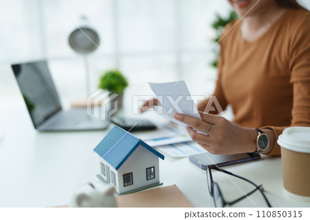 asian woman are using a calculator to calculate the loan period each month 110850315